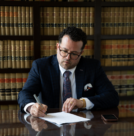 Attorney reviewing legal documents at a desk in a law library