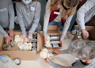 Top view of group of volunteers working in community charity donation center, food bank and coronavirus concept.